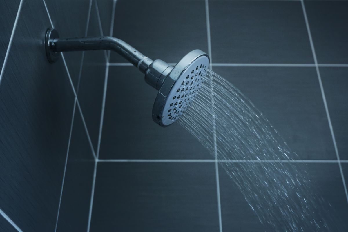 Shower head in bathroom with water drops flowing  